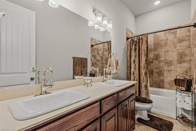 a bathroom with a double vanity sink mirror and toilet
