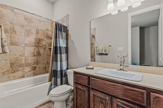 a bathroom with a sink a toilet a mirror and shower