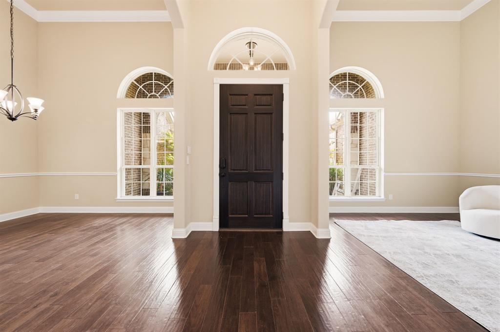 7013 Handel Colleyville, TX 76034 - Photo 8 of 37 Entryway featuring dark wood-finish flooring, a dark wood-finish front door with an arched transom, and two arched windows