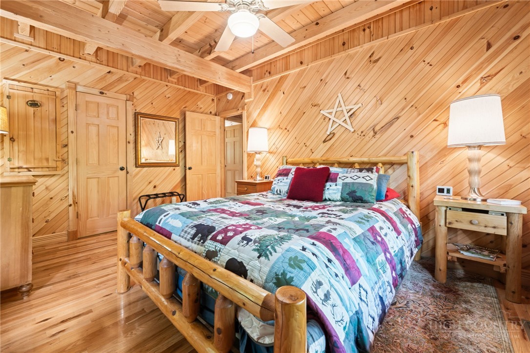 613 Silas Creek Road Lansing, NC 28643 - Photo 28 of 40 a bedroom with a bed and wooden floor