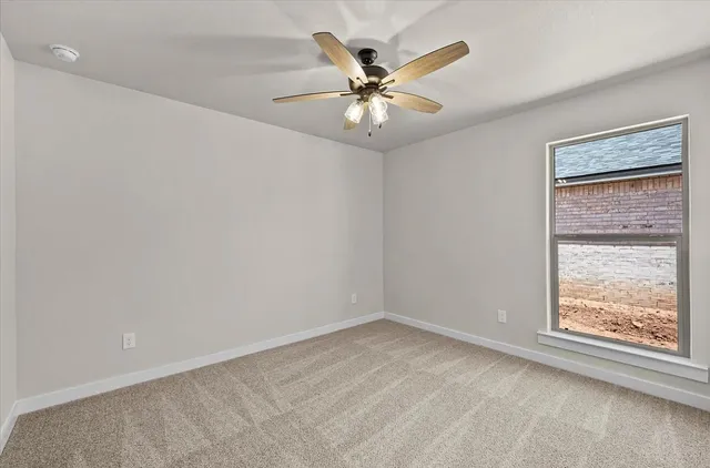 an empty room with a window and a fan