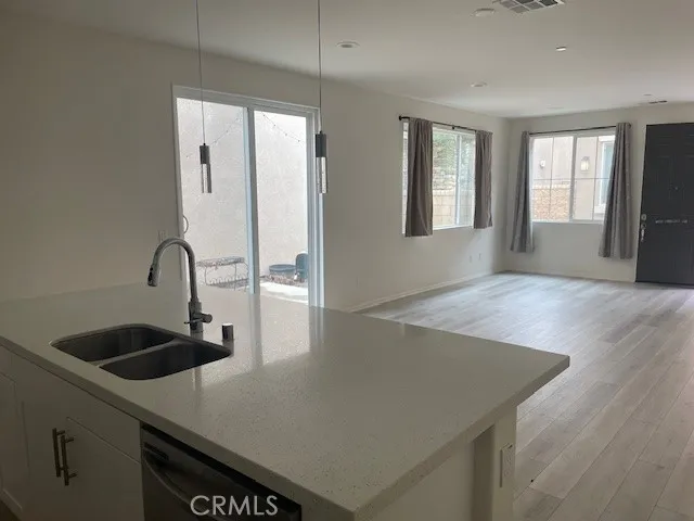 a view of kitchen island a sink wooden floor and kitchen living room