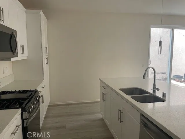 a kitchen with stainless steel appliances granite countertop a sink and a stove