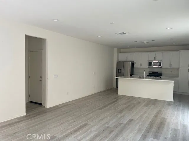 a view of kitchen with refrigerator and wooden floor