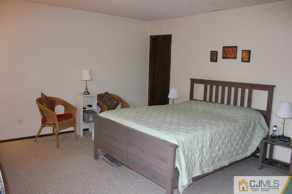 8007 Hana Road Edison, NJ 08817 - Photo 11 of 20 a bedroom with a bed and chair