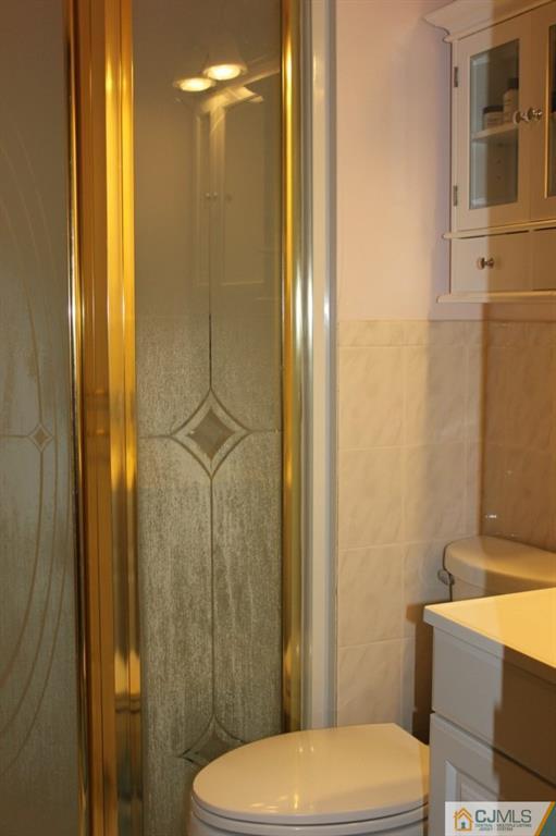 8007 Hana Road Edison, NJ 08817 - Photo 18 of 20 a bathroom with a sink a toilet a shower and a mirror