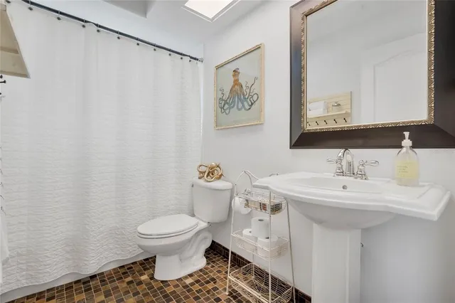 a bathroom with a sink toilet and a mirror