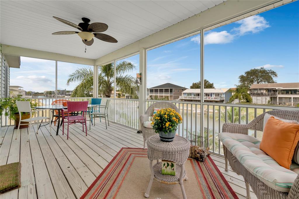 4049 Cobia Drive Hernando Beach, FL 34607 - Photo 18 of 40 a living room with furniture dining table a chandelier and a floor to ceiling window