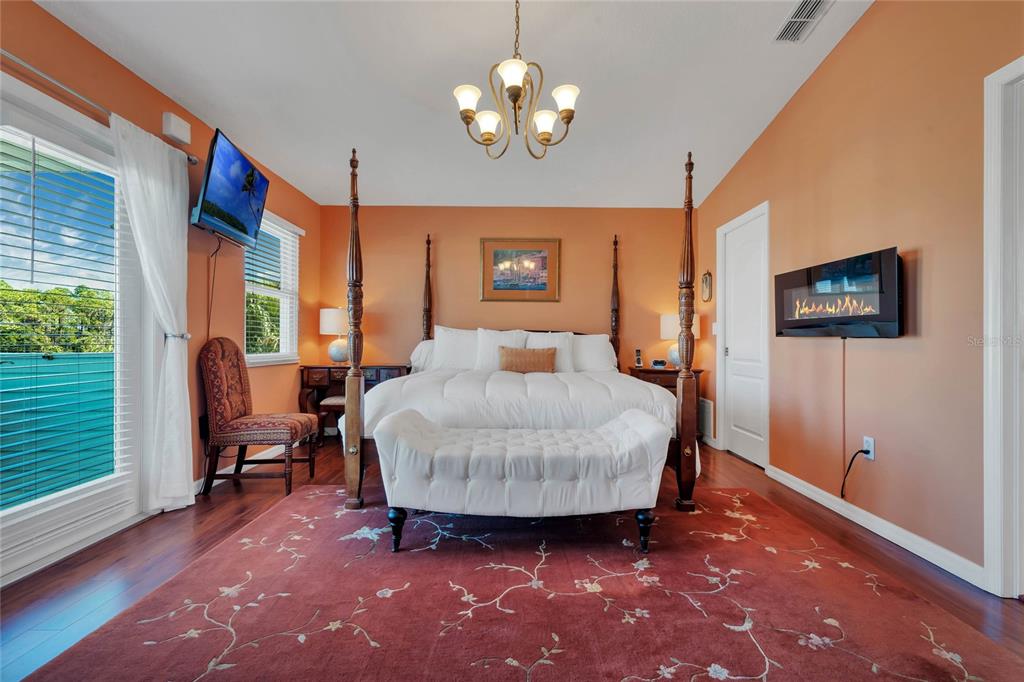 4049 Cobia Drive Hernando Beach, FL 34607 - Photo 19 of 40 a spacious bedroom with a bed and a chandelier