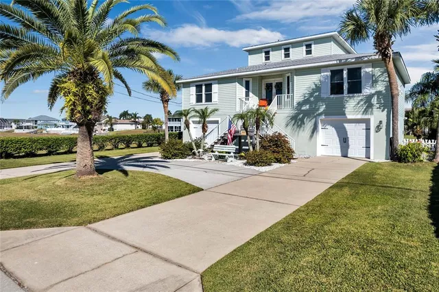 a view of a house with a yard and palm trees