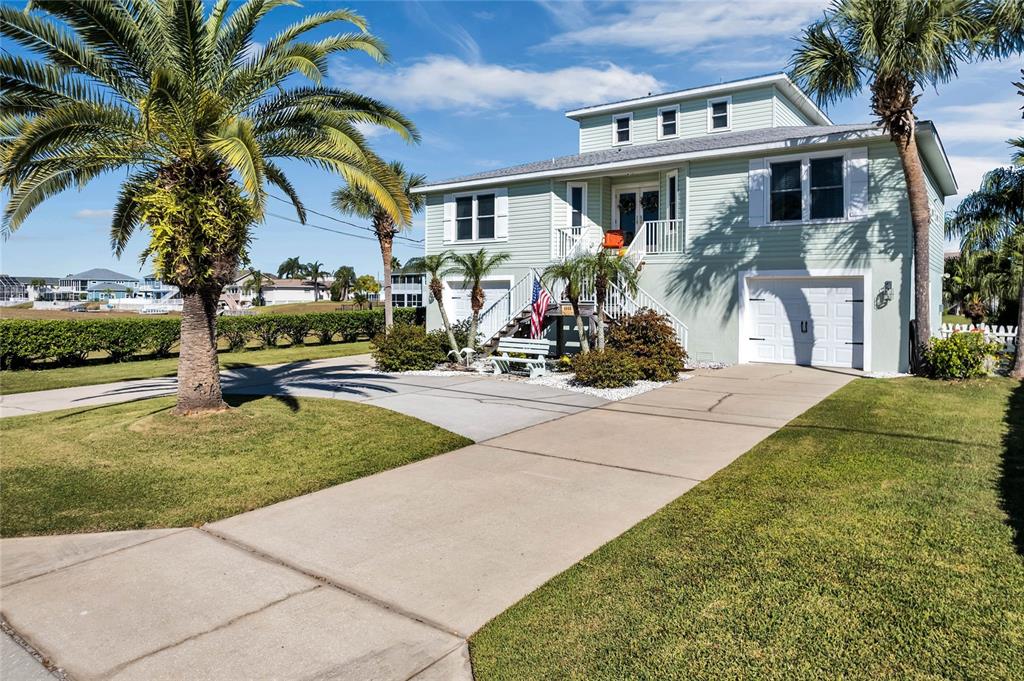 4049 Cobia Drive Hernando Beach, FL 34607 - Photo 2 of 40 a view of a house with a yard and palm trees