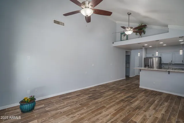 a view of an empty room with kitchen and a window