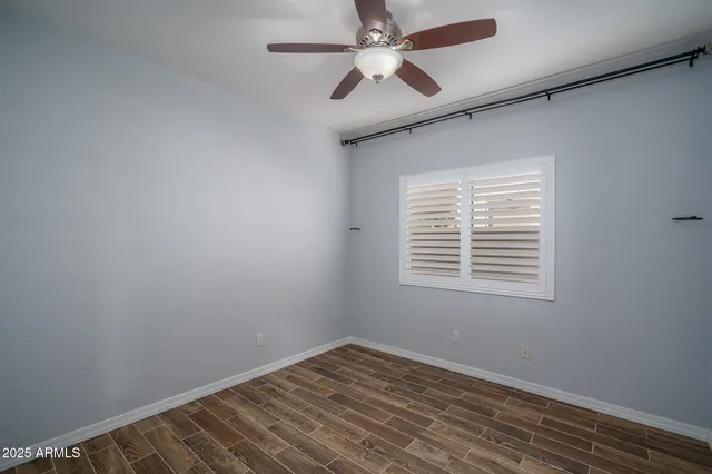 an empty room with a window and a fan