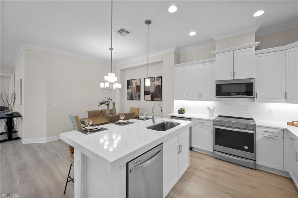 6385 Arriba Avenue Naples, FL 34113 - Photo 6 of 43 a kitchen with stainless steel appliances granite countertop a sink a stove and a refrigerator