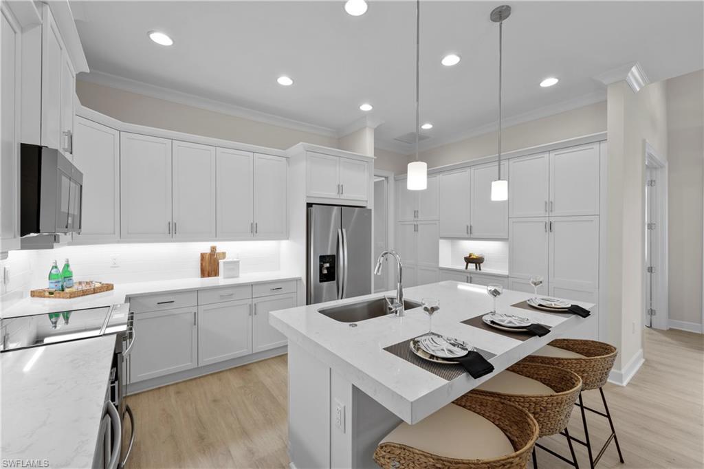 6385 Arriba Avenue Naples, FL 34113 - Photo 7 of 43 a kitchen with a sink stove and refrigerator