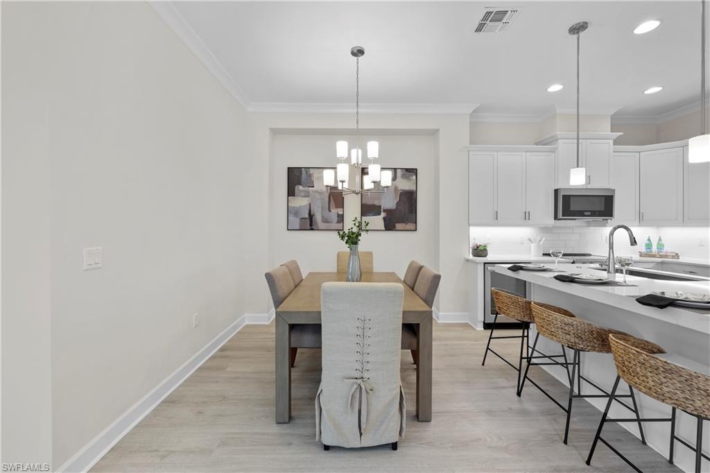 6385 Arriba Avenue Naples, FL 34113 - Photo 8 of 43 a view of a dining room with furniture window and wooden floor