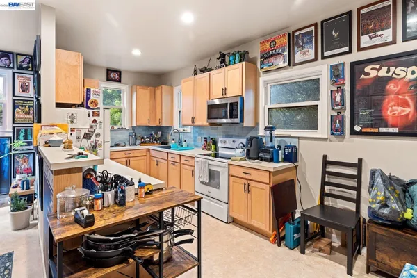 a kitchen with stainless steel appliances a stove a refrigerator and a dining table