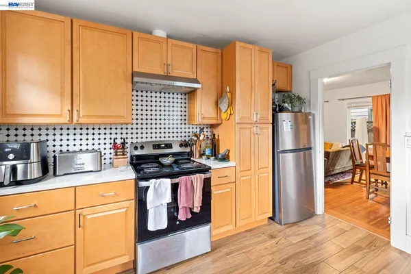 a kitchen with stainless steel appliances granite countertop a refrigerator a stove and a sink
