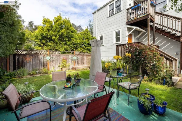 a view of a chair and table in backyard of the house