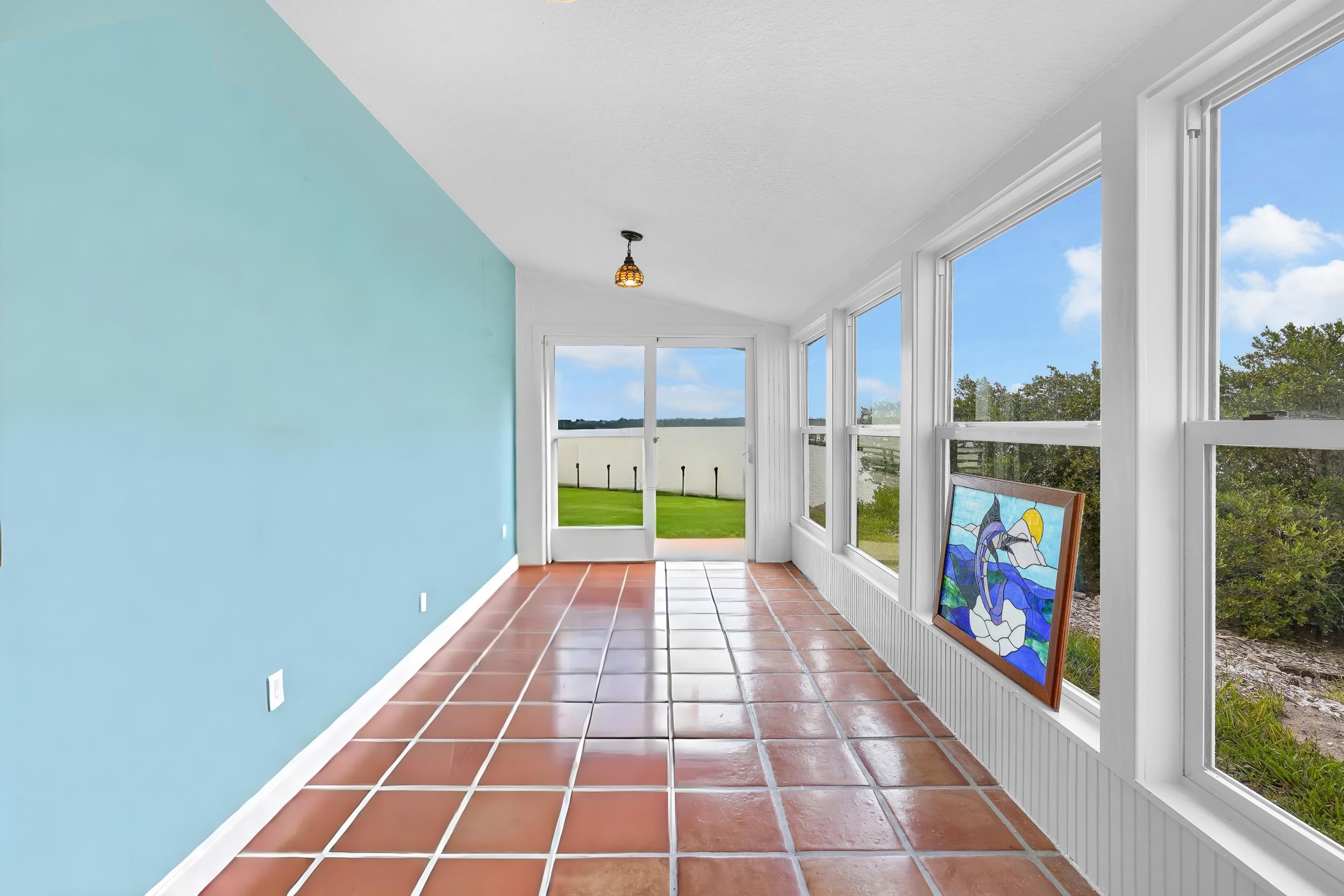 7337 A1A South St. Augustine, FL 32080 - Photo 11 of 100 Unfurnished sunroom featuring vaulted ceiling, tile patterned floors, and a water view