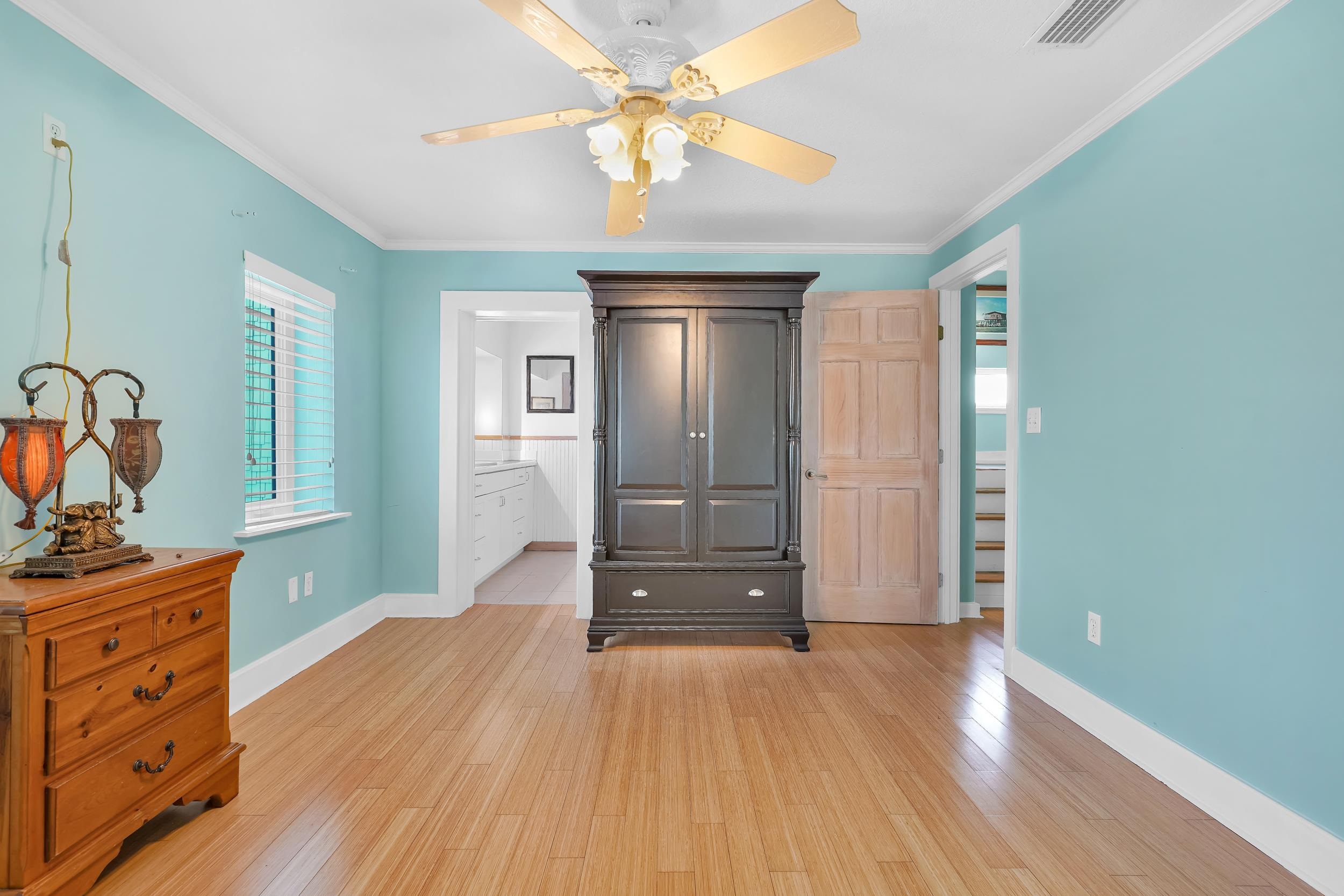 7337 A1A South St. Augustine, FL 32080 - Photo 16 of 100 Bedroom with crown molding, a ceiling fan, light wood-style floors, and ensuite bath