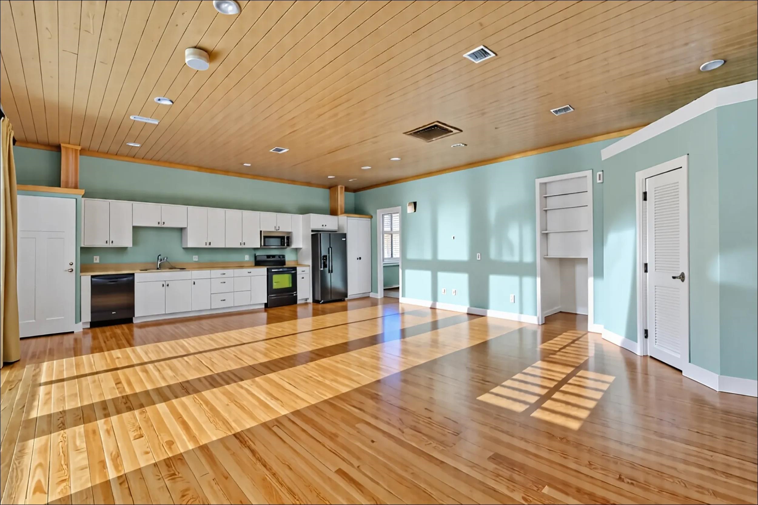 7337 A1A South St. Augustine, FL 32080 - Photo 100 of 100 Kitchen view from the living room - white cabinets, open floor plan, light wood-style floors, wood ceiling, and black appliances