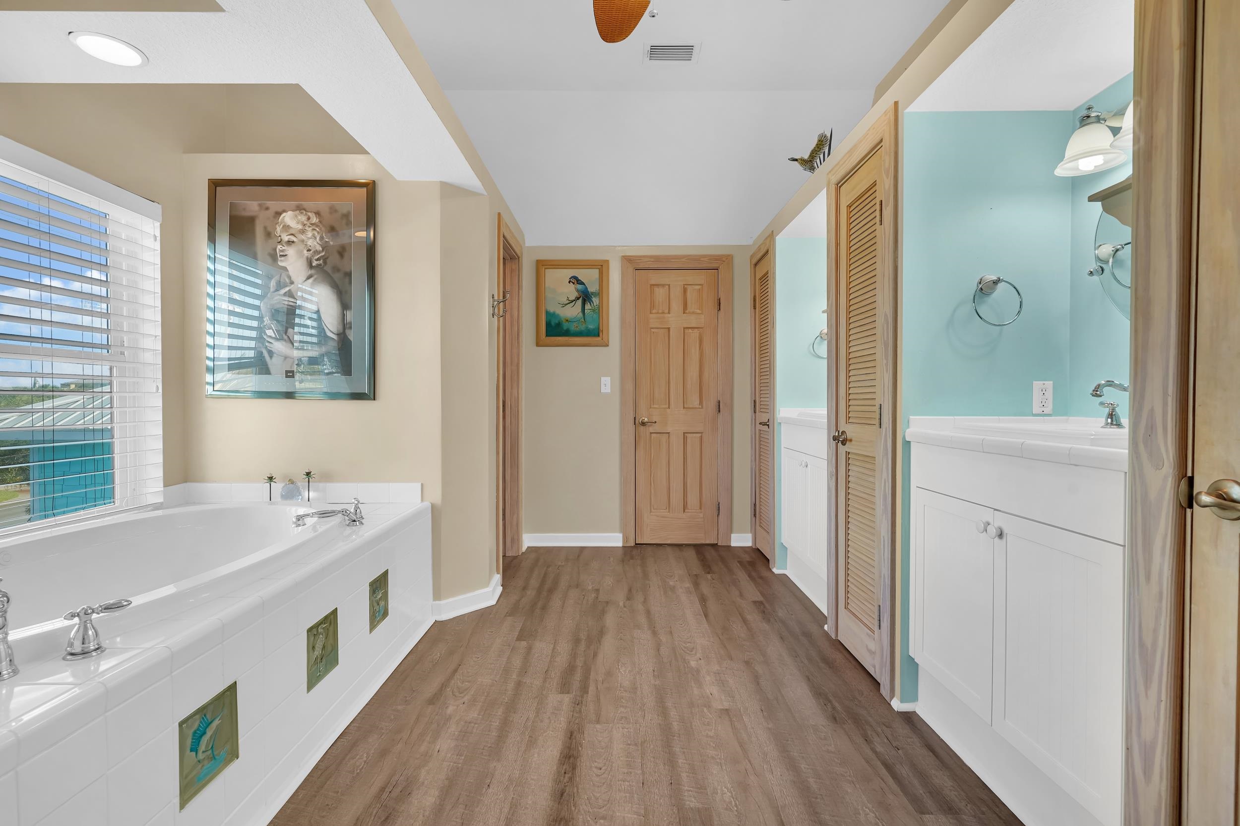 7337 A1A South St. Augustine, FL 32080 - Photo 53 of 100 Full bath with a closet, vanity, a bath, wood finished floors, and a ceiling fan