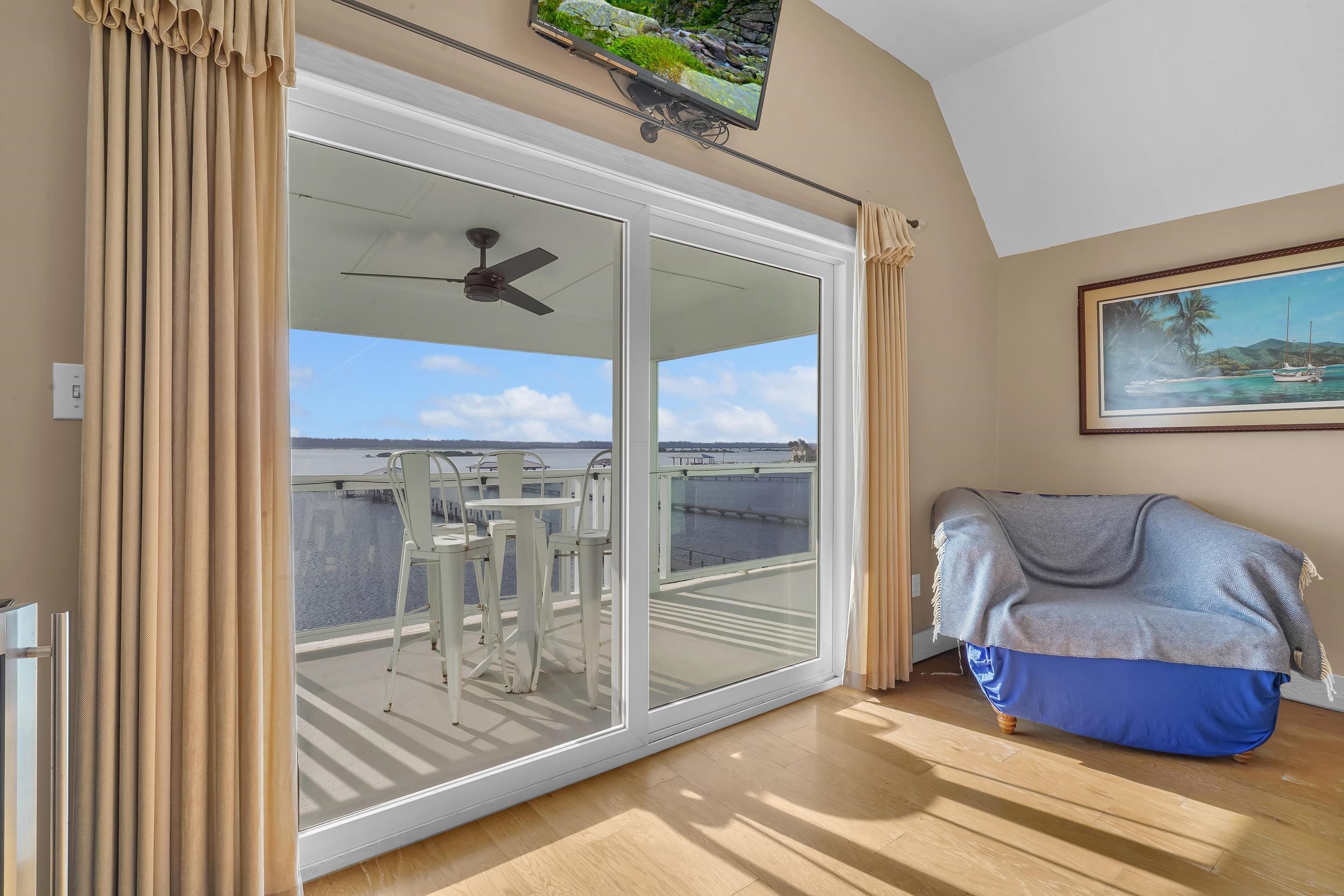 7337 A1A South St. Augustine, FL 32080 - Photo 55 of 100 Glass Doors to Balcony off Primary Bedroom with wood finished floors, vaulted ceiling, and ceiling fan
