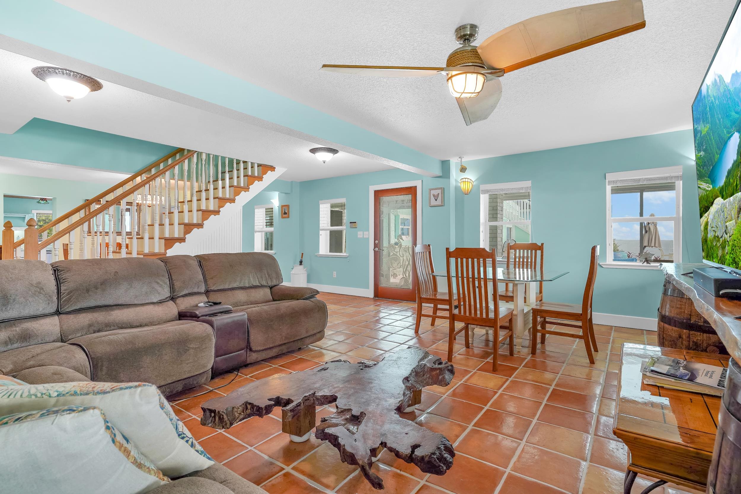 7337 A1A South St. Augustine, FL 32080 - Photo 66 of 100 Living area featuring a textured ceiling, light tile patterned floors, ceiling fan, and stairs