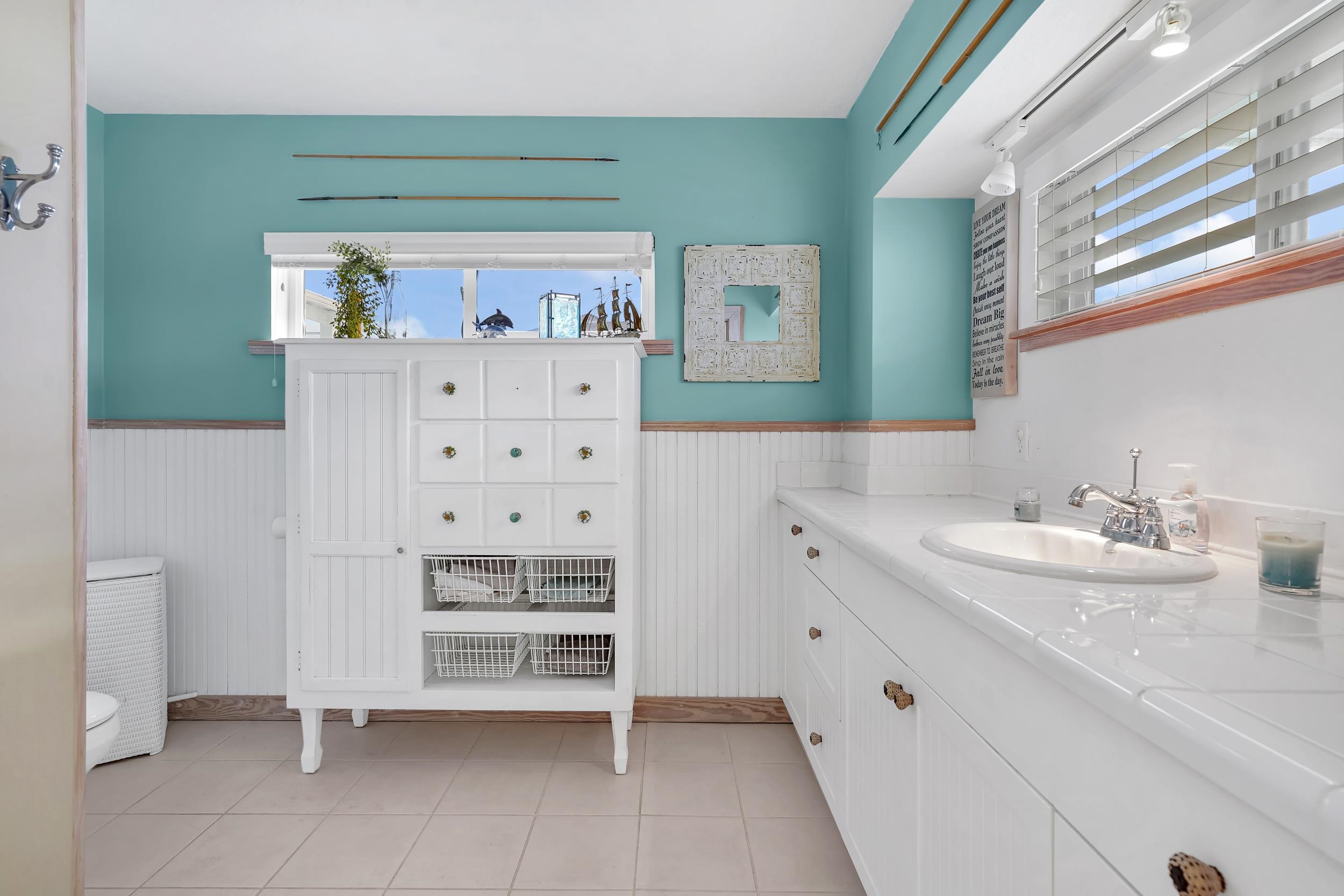 7337 A1A South St. Augustine, FL 32080 - Photo 68 of 100 Bathroom with vanity, light tile patterned flooring, and wainscoting