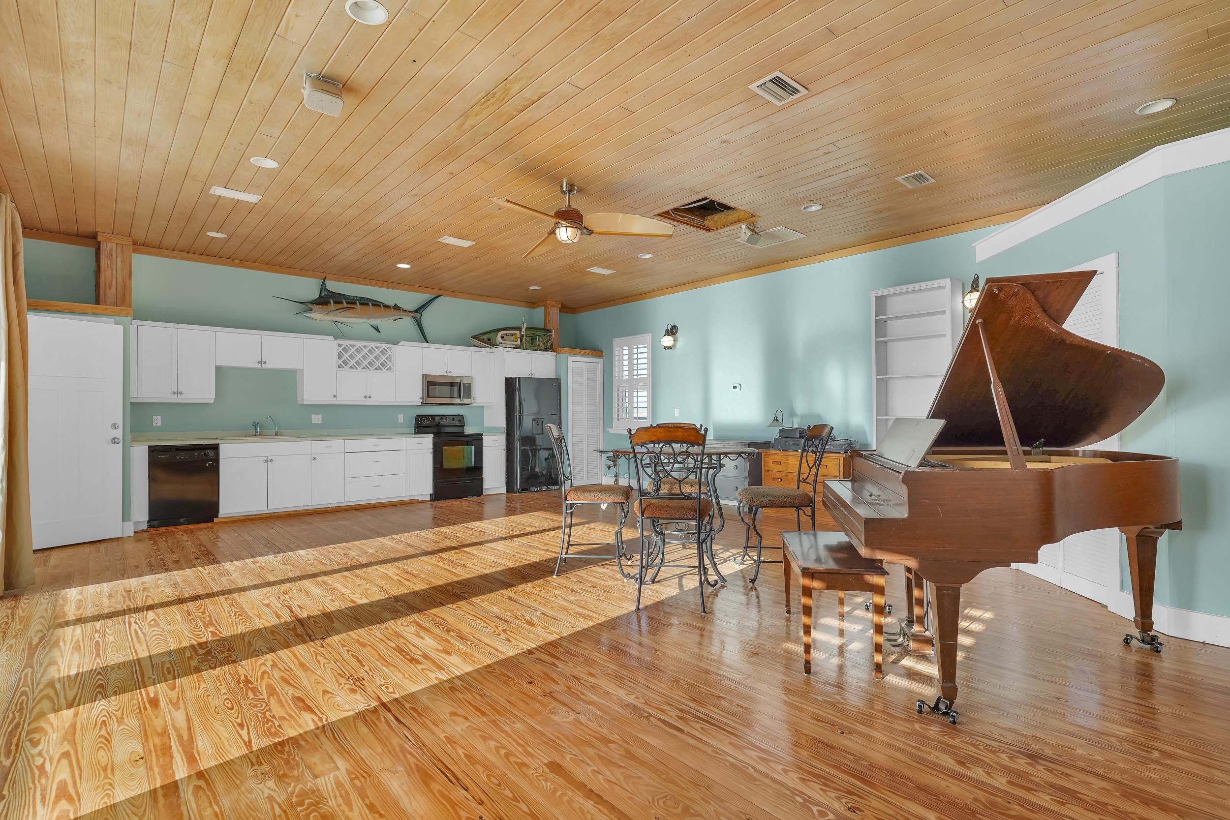 7337 A1A South St. Augustine, FL 32080 - Photo 69 of 100 Kitchen featuring white cabinets, black appliances, wood ceiling, ceiling fan, and ornamental molding. Living Area & Dining area as well