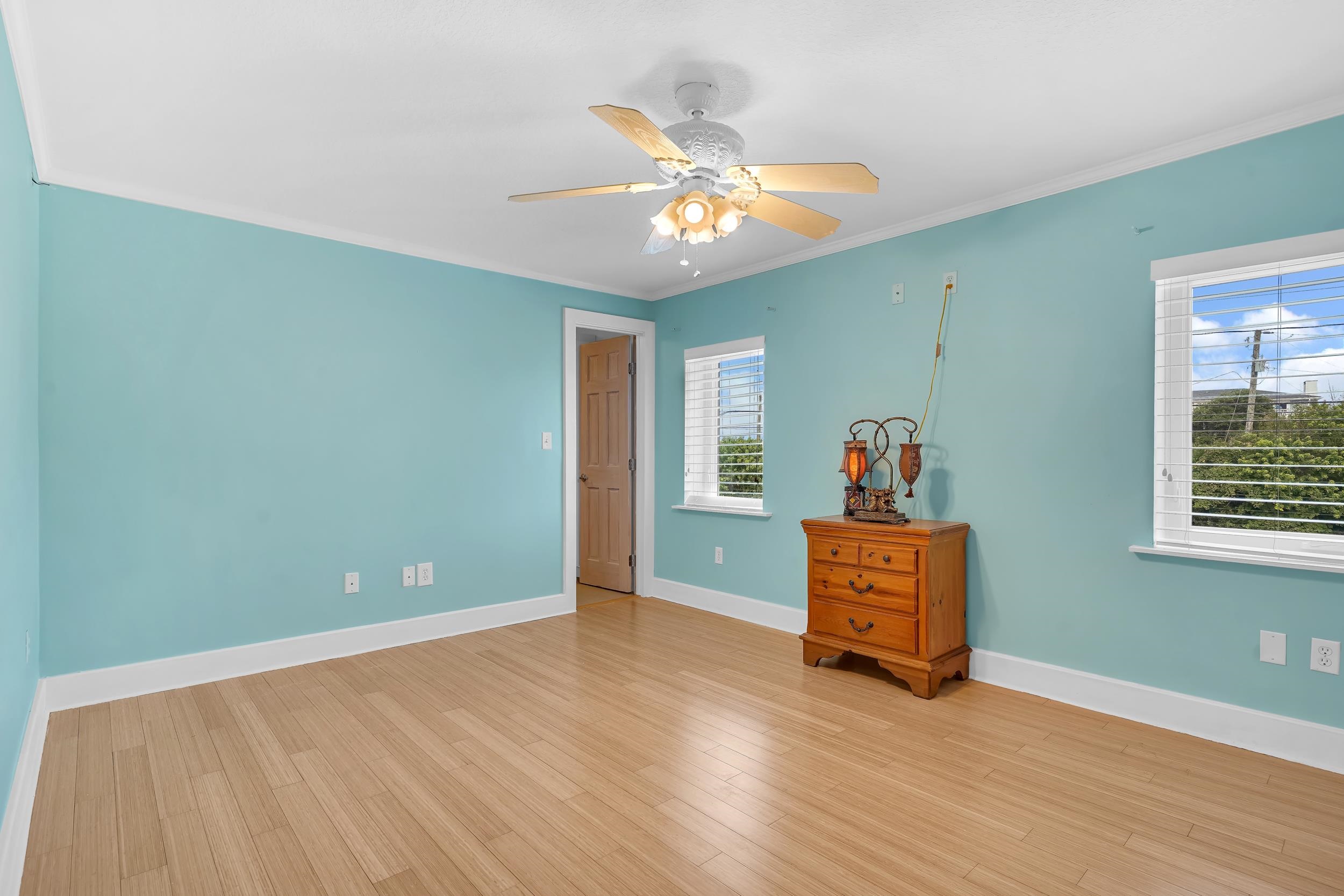 7337 A1A South St. Augustine, FL 32080 - Photo 78 of 100 Unfurnished bedroom with crown molding, light wood-style floors, and ceiling fan