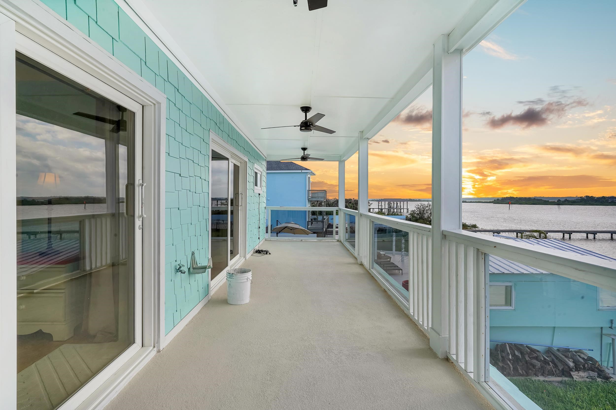 7337 A1A South St. Augustine, FL 32080 - Photo 80 of 100 Balcony at dusk featuring ceiling fan, a water view, and a sunroom