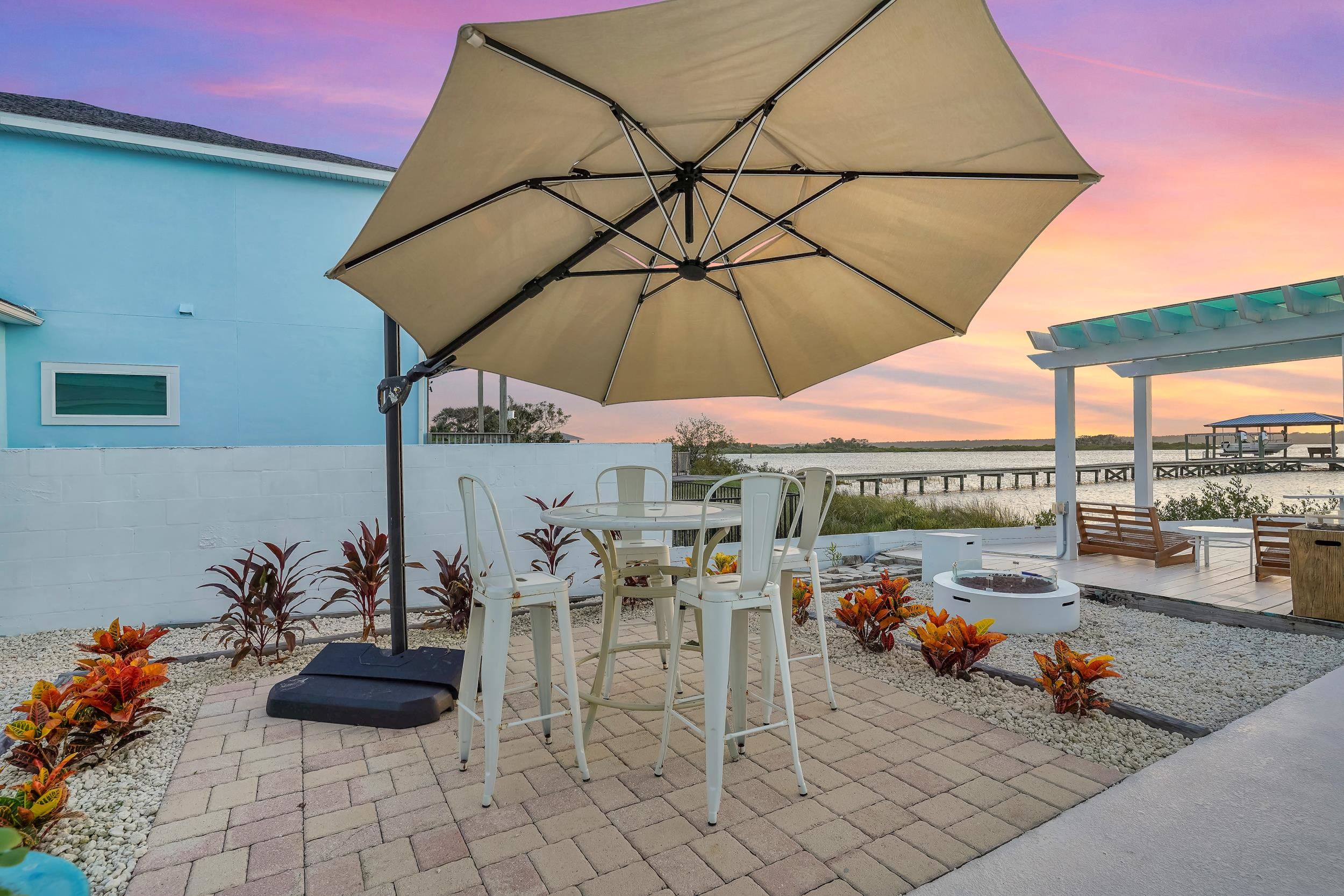 7337 A1A South St. Augustine, FL 32080 - Photo 89 of 100 Patio terrace at dusk with a water view, a patio, outdoor dining area, and a fire pit