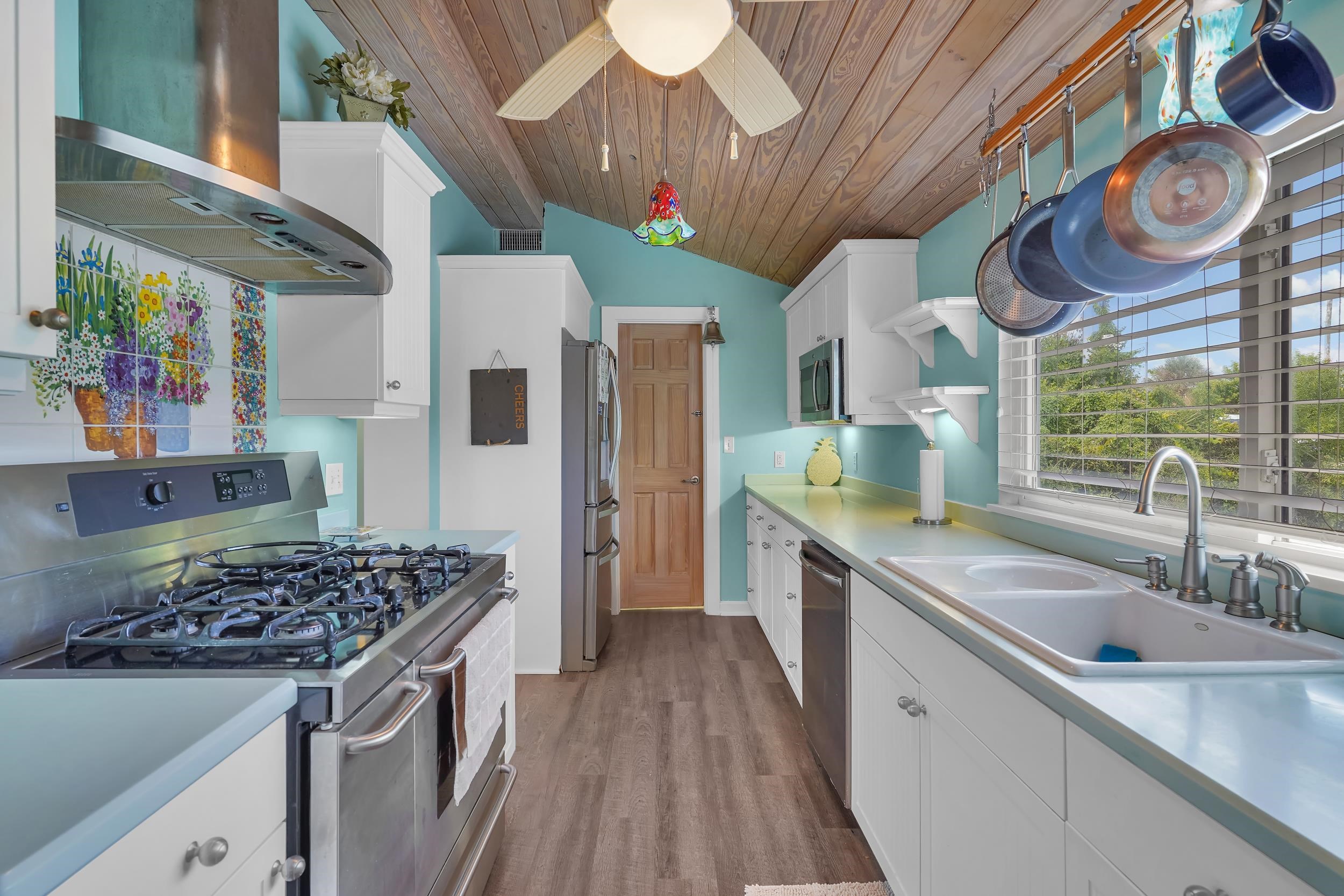 7337 A1A South St. Augustine, FL 32080 - Photo 96 of 100 Kitchen featuring stainless steel appliances, white cabinetry, wall chimney exhaust hood, vaulted ceiling, and wooden ceiling