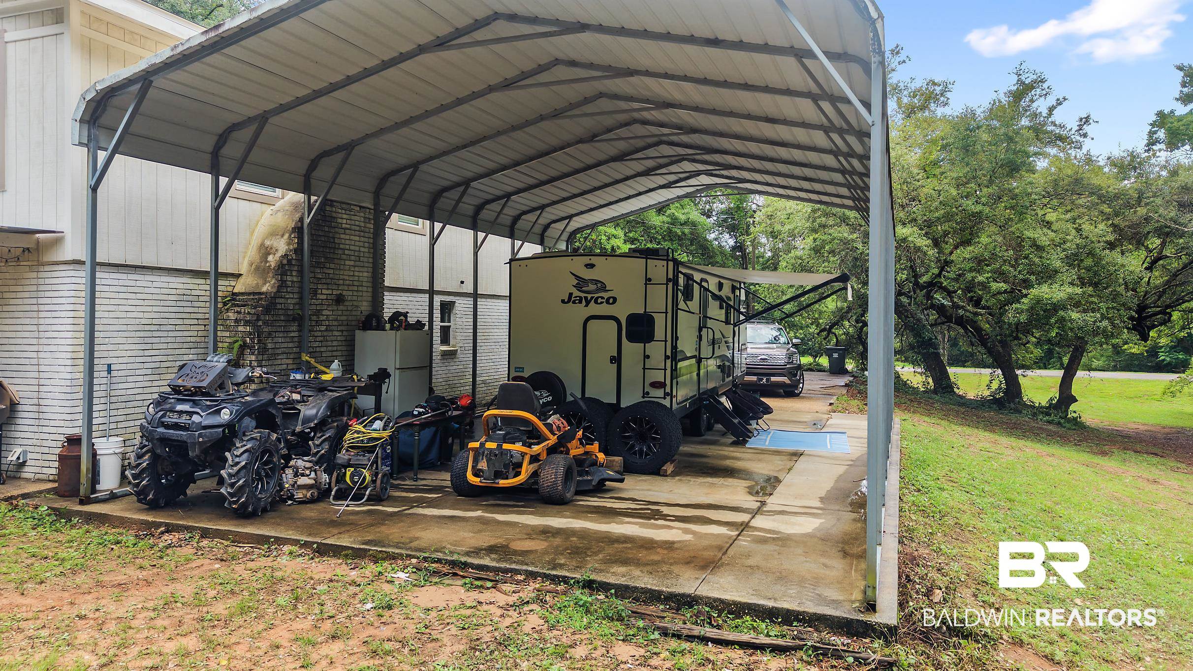 33129 Antietam Road Lillian, AL 36549 - Photo 29 of 31 Expansive metal carport with a concrete slab, offering ample covered parking and outdoor storage
