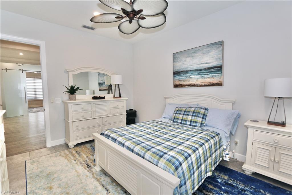 8337 Promoso Court Naples, FL 34114 - Photo 25 of 48 a bedroom with a bed and a chandelier