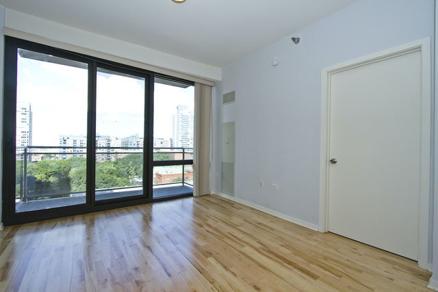 1 East 8th Street, Unit 802 Chicago, IL 60605 - Photo 2 of 12 wooden floor in an empty room with a window