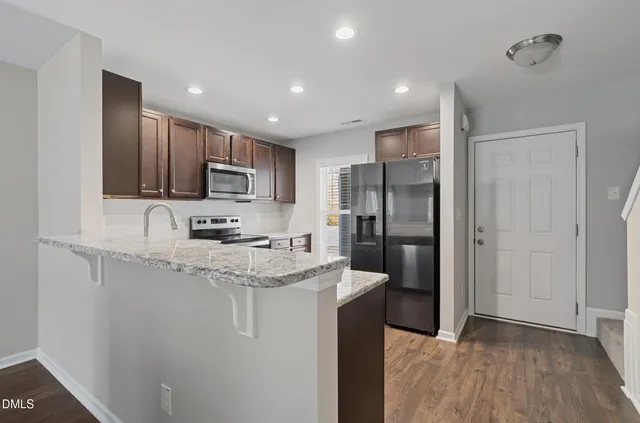a kitchen with stainless steel appliances granite countertop a refrigerator sink and microwave