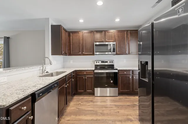 a kitchen with stainless steel appliances granite countertop a sink stove and refrigerator