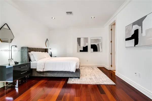 a bedroom with a large bed and a chandelier
