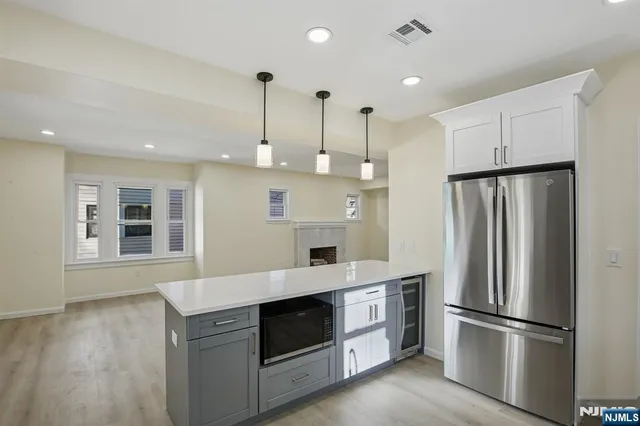 a kitchen with kitchen island white cabinets and stainless steel appliances