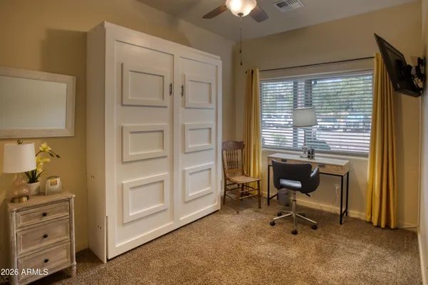a view of a workspace with furniture and a window