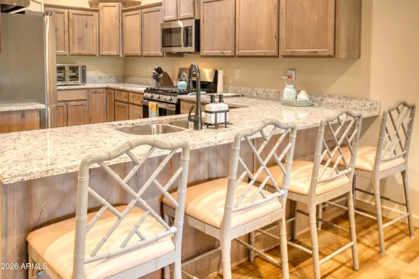 a view of a kitchen with kitchen island granite countertop a sink and counter top space