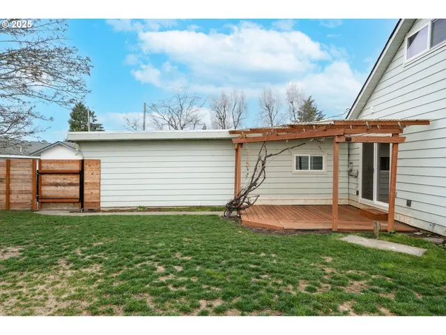 a view of a wooden house with a large window and wooden fence