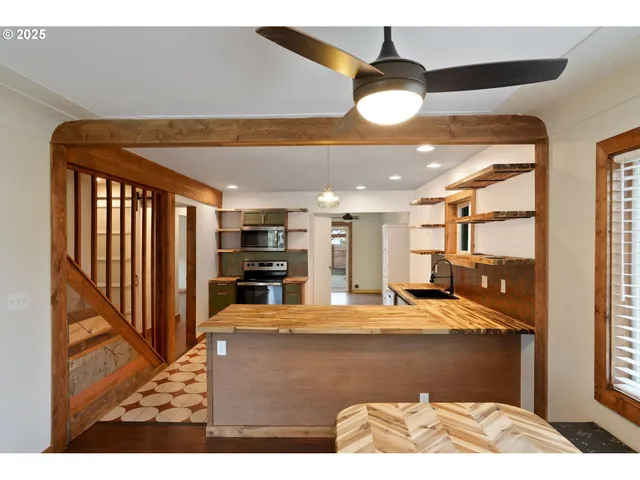 a living room with stainless steel appliances kitchen island granite countertop furniture and a chandelier