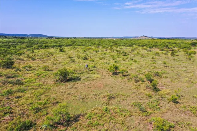 a view of a green field with an ocean view