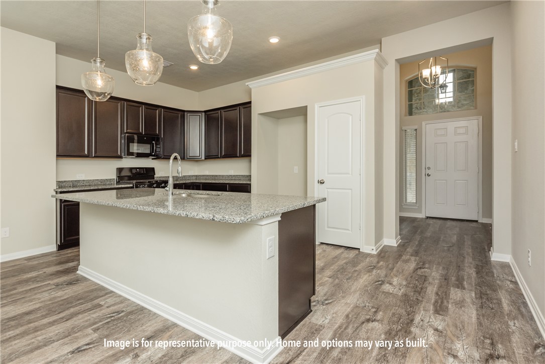 1913 Meridian Court Bryan, TX 77807 - Photo 14 of 15 a kitchen with kitchen island cabinets and stainless steel appliances