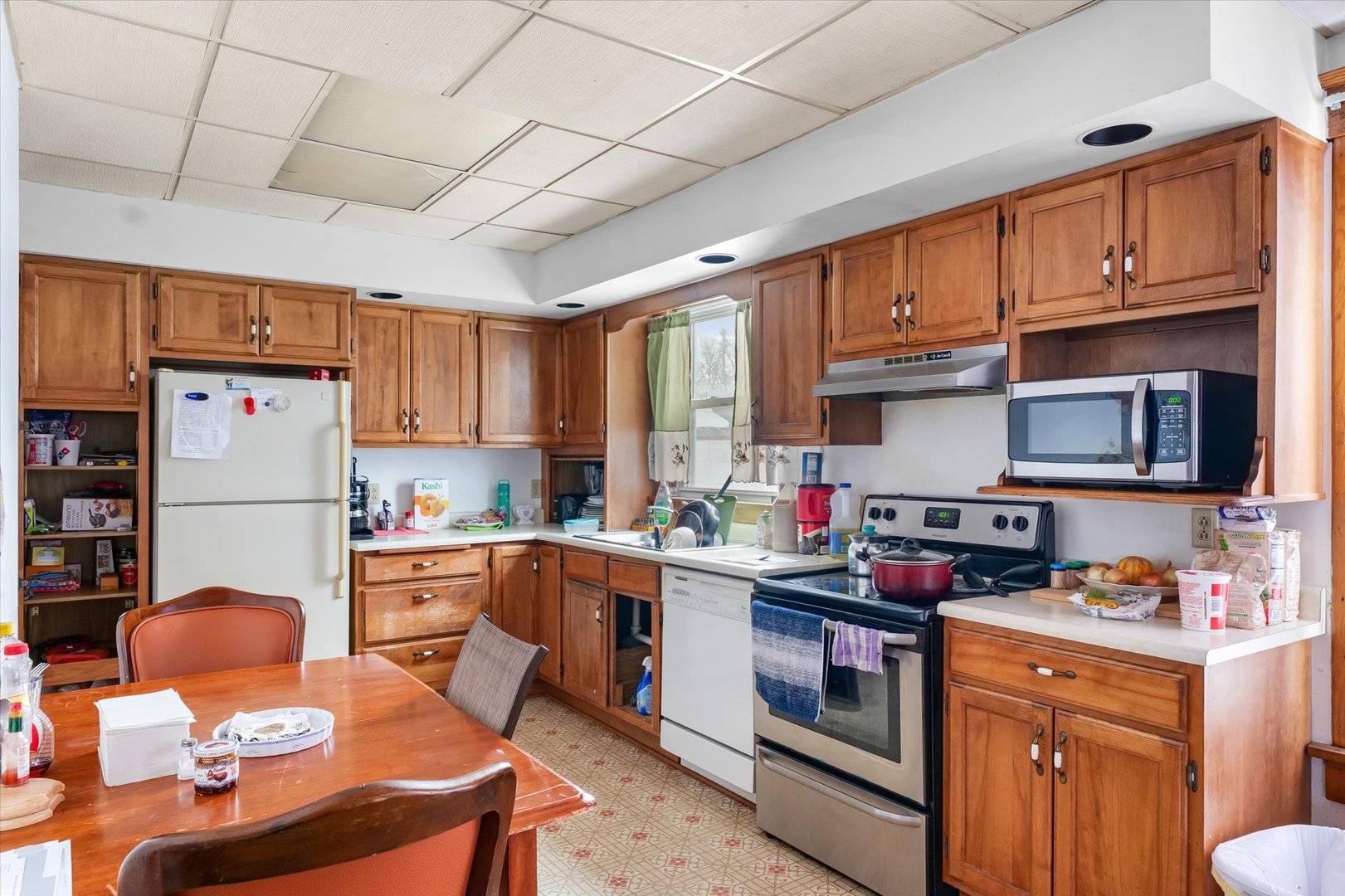 209 North Green Street Melvin, IL 60952 - Photo 11 of 24 a kitchen with stainless steel appliances granite countertop a stove top oven a sink dishwasher and cabinets with wooden floor