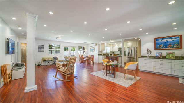 a view of a living room kitchen with furniture and wooden floor